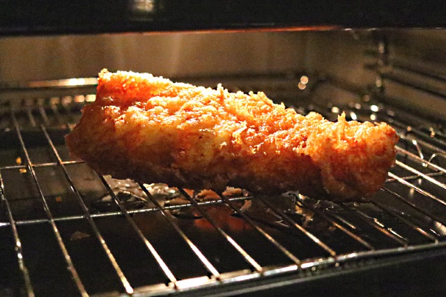 Battered fish kept warm in an oven, draining excess oil