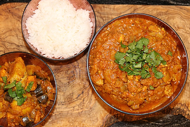 Pork curry, rice and potato and aubergine curry side dishes